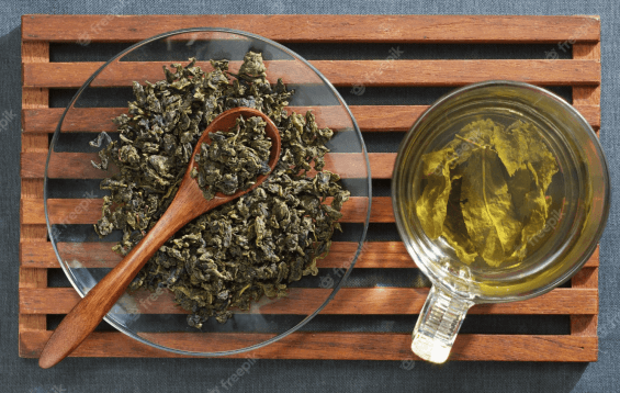cup of tea next a plate filled with bits of marijuana. Marijuana is brownish, indicating that it's already been vaped. It's used as a tea spice.